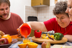 disabled woman with her caregivers cooking together